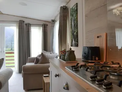 a kitchen with a stove top oven next to a couch at Watches - Uk13544 in Bassenthwaite