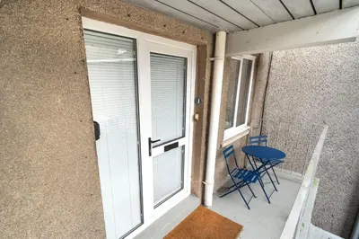 a porch with a table and chairs and a window at Fellseeker in Keswick