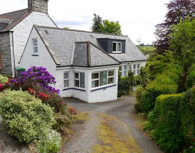 a white house with a driveway in front of it at Rowan Cottage in New Galloway