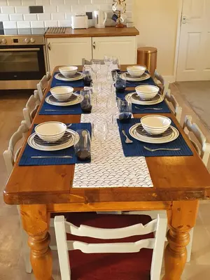 a wooden table with plates and dishes on it at Lovely Cottage on Hadrians Wall 12 Miles From Carlisle in Carlisle