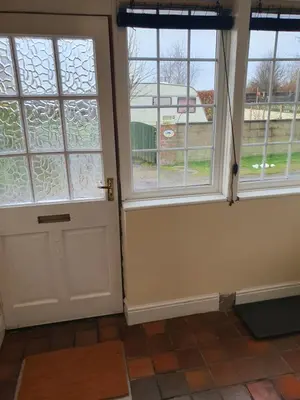 a room with two windows and a door at Lovely Cottage on Hadrians Wall 12 Miles From Carlisle in Carlisle