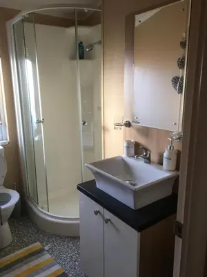 a bathroom with a sink and a shower and a toilet at STUNNING LODGE - HOME FROM HOME Kippford, Dalbeattie in Dalbeattie