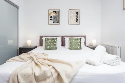 a bedroom with a white bed with a blanket and pillows at Elliot Suite No 1 - Donnini Apartments in Ayr