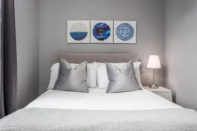a bedroom with a white bed with four pillows at Elliot Suite No3 - Donnini Apartments in Ayr