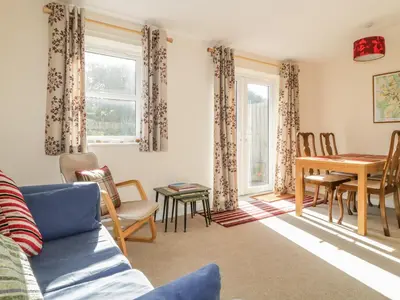 a living room with a couch and a table and chairs at Rowan Cottage in St Bees