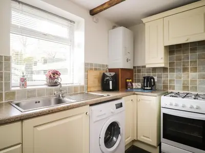 a kitchen with a sink and a dishwasher at Mousehole Cottage in Carlisle