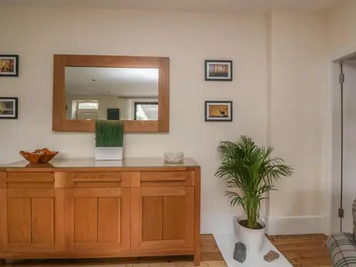 a mirror on a dresser in a room with a plant at Hillcrest in Newton Stewart