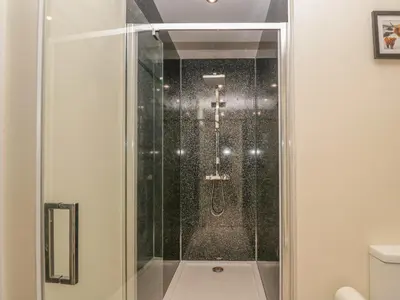 a shower with a glass door in a bathroom at Hillcrest in Newton Stewart
