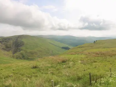 a green hillside with mountains in the background at Apartment 1 St Mary's Church in Moffat