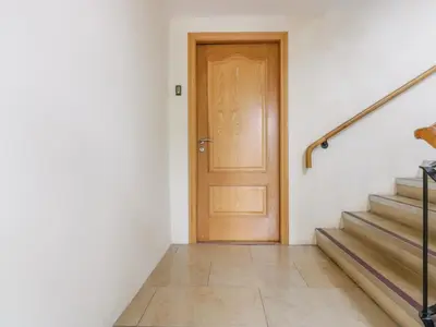 a wooden door in a white room with stairs at Apartment 1 St Mary's Church in Moffat