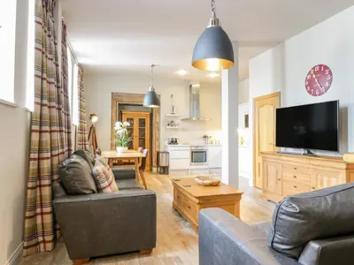 a living room with a couch and a tv at Duplex in Moffat