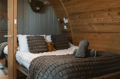 a bed with pillows on it in a room at The Huts at Highside Farm in Keswick