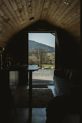 a living room with a table and a window at The Huts at Highside Farm in Keswick
