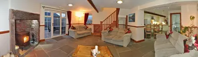 a living room with couches and a fireplace at THE OLD FARMHOUSE in Holmrook