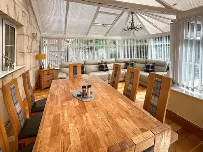 a living room with a wooden table and a couch at West Fells Cottage in Arlecdon