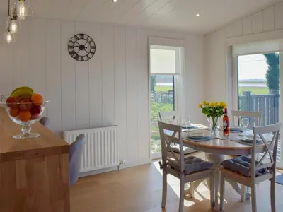 a kitchen and dining room with a table and chairs at Willow Lodge - Uk13637 in Creetown