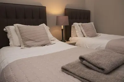 a bedroom with two beds with white sheets and pillows at Bakers Rest ideal for 2 families centrally located in Grasmere with walks from the door in Grasmere