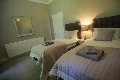a hotel room with two beds and a mirror at Bakers Retreat spacious 1st floor apartment centrally located in Grasmere in Ambleside