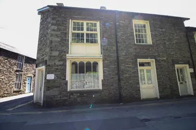 a brick building with white windows on a street at Bakers Retreat spacious 1st floor apartment centrally located in Grasmere in Ambleside