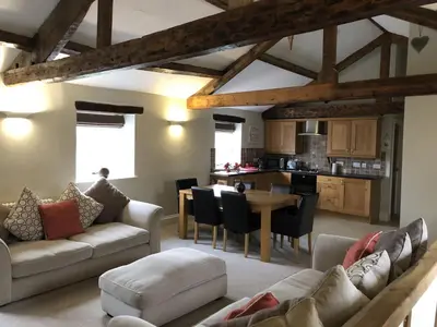 a living room with a couch and a table at Carleton Mill with open views to River on the outskirts of Carlisle & 20 mins to Ullswater in Carlisle