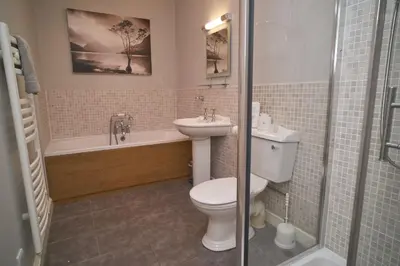 a bathroom with a toilet and a sink and a tub at Old Bakers Cottage ground floor apartment centrally located in Grasmere with patio area in Grasmere