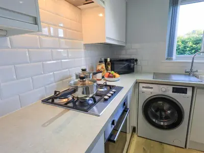 a kitchen with a stove and a washing machine at Fairfell in Keswick