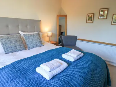 a bed with two towels on a blue blanket at Fairfell in Keswick