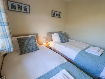 two twin beds in a room with a lamp at Fairfell in Keswick
