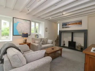a living room with two couches and a fireplace at Low Melbecks House in Keswick