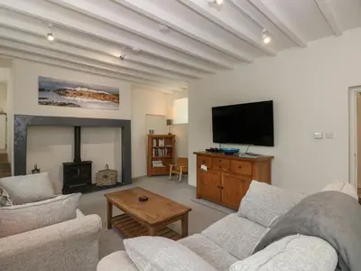 a living room with a couch and a tv and a fireplace at Low Melbecks House in Keswick