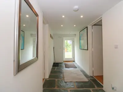 a hallway with a mirror and a tile floor at Low Melbecks House in Keswick