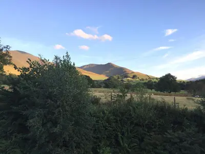 a view of a field with mountains in the background at Low Melbecks House in Keswick
