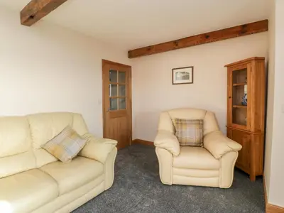 a living room with a couch and two chairs at 2 Whiterow in Powfoot