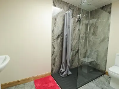 a shower with a glass door in a bathroom at 2 Whiterow in Powfoot