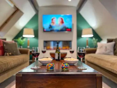 a living room with a table with glasses of wine at Geltsdale East Wing sleeps 6 with River Eden views near Carlisle & Ullswater in Wetheral