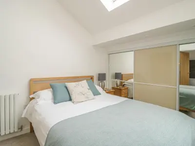 a bedroom with a large bed with blue pillows at Coney Garth Barn in Beckermet
