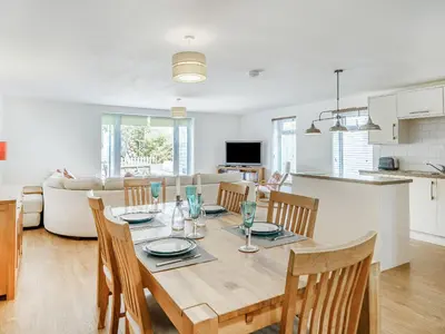 a dining room and kitchen with a table and chairs at Coney Garth Barn in Beckermet