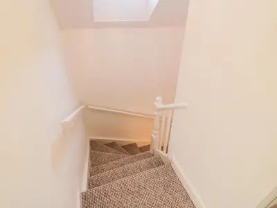 a stairway with a white wall and a window at 1 Alpine Place in Thornhill