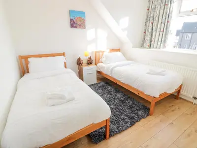 two twin beds in a room with a window at 1 Alpine Place in Thornhill