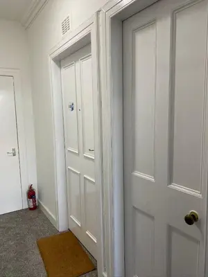 a white door in a room with a rug next to it at Stylish 2nd Floor Georgian Period Flat in Dumfries