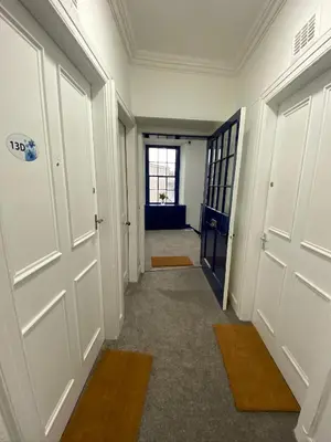 an empty hallway with white doors and a window at Stylish 2nd Floor Georgian Period Flat in Dumfries