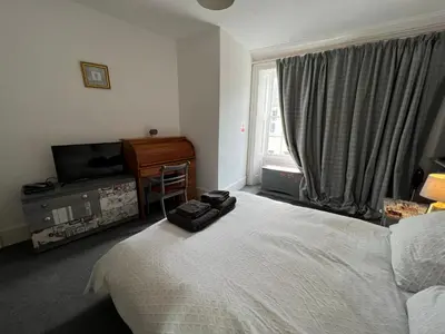 a bedroom with a bed and a desk and a television at Stylish 2nd Floor Georgian Period Flat in Dumfries