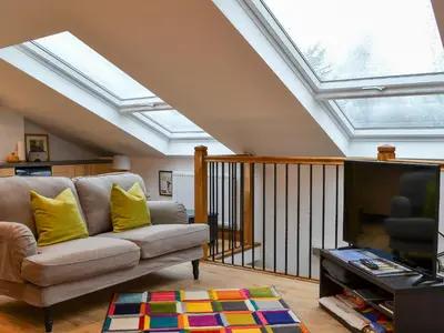 a living room with a couch and a skylight at Apple Barn in Applethwaite