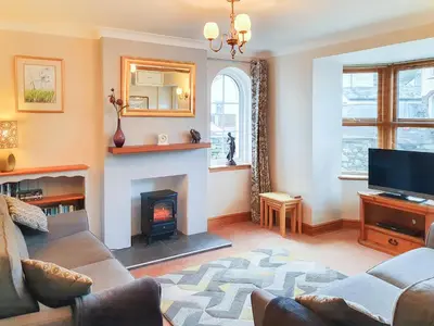 a living room with a couch and a fireplace at Apple Cross in Keswick