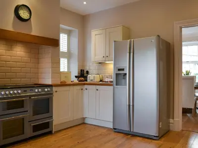 a kitchen with a refrigerator and a clock on the wall at Rowan House in Threlkeld
