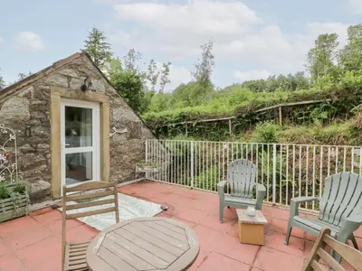 a patio with two chairs and a table at The Barn in Dalbeattie