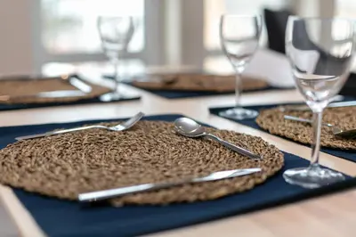 a table with plates and silverware and glasses on it at The Lucas - Donnini Apartments in Ayr