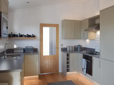 a kitchen with a sink and a stove top oven at Cree Lodge - Uk13636 in Creetown