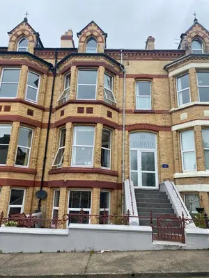 a large brick building with stairs in front of it at Ashfield Guesthouse in Douglas