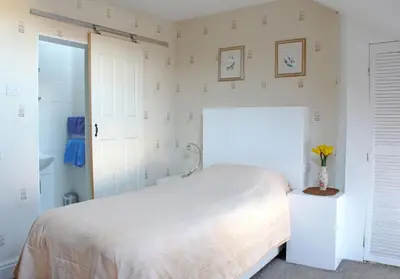 a bedroom with a bed and a vase of flowers on a table at Ashfield Guesthouse in Douglas
